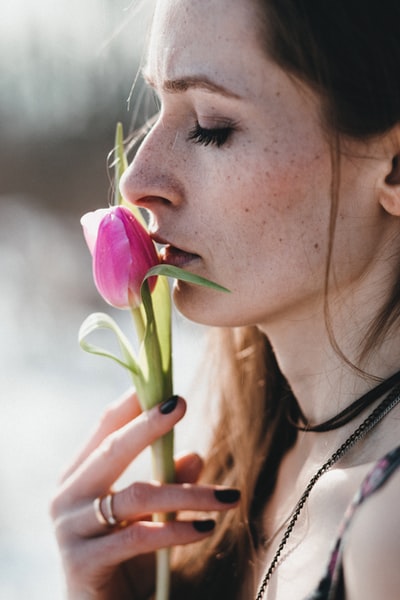 女人拿着粉红色的玫瑰花蕾
